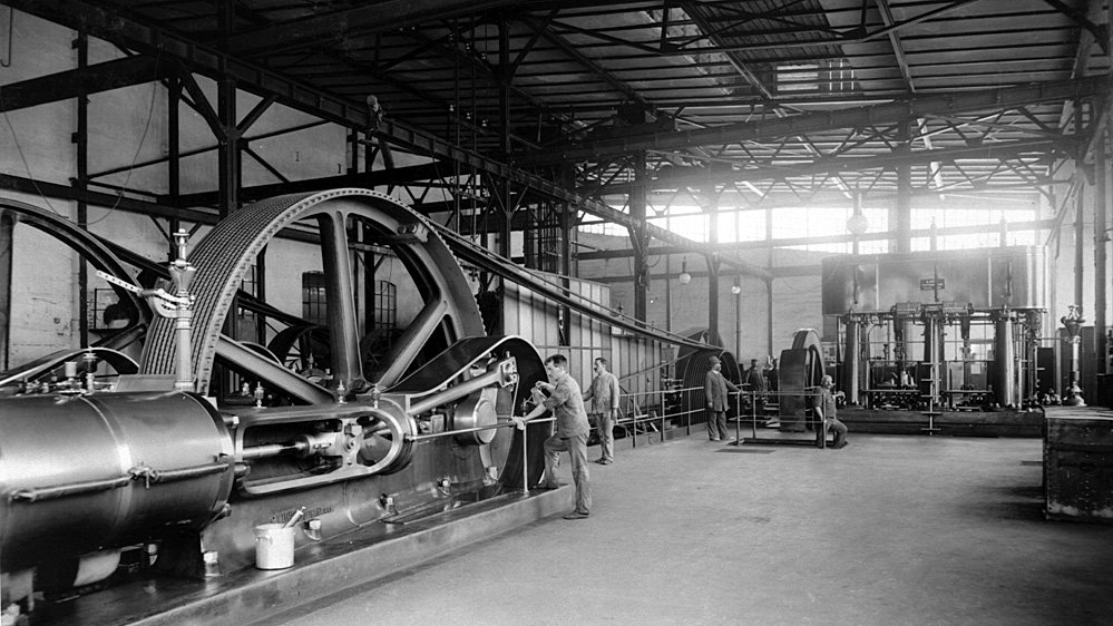Workers on a factory floor with antiquated machinery