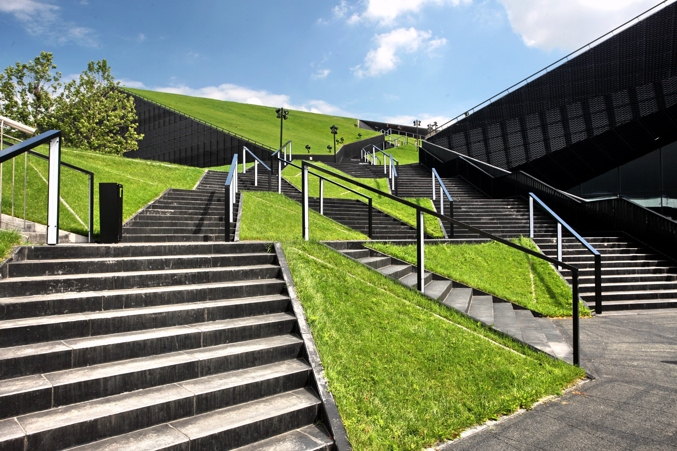 Treppen führen hinauf zu einem grünen Hügel