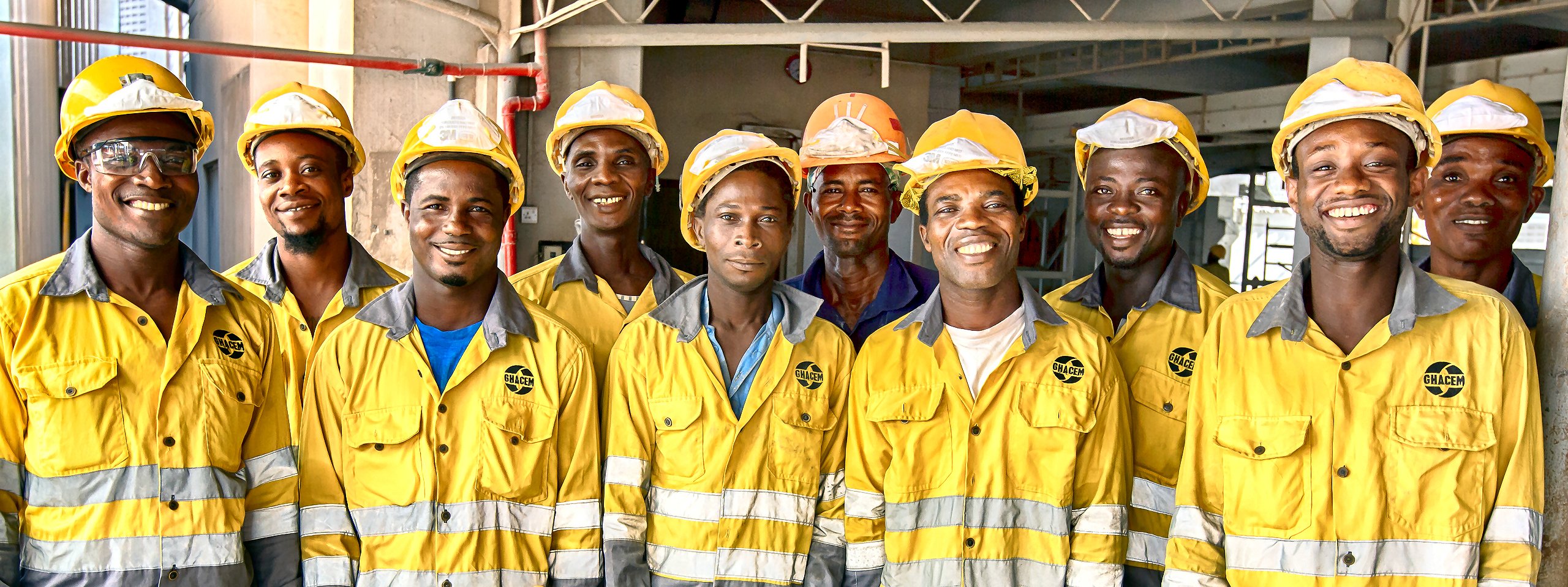 Ten construction workers from Africa are smiling into the camera