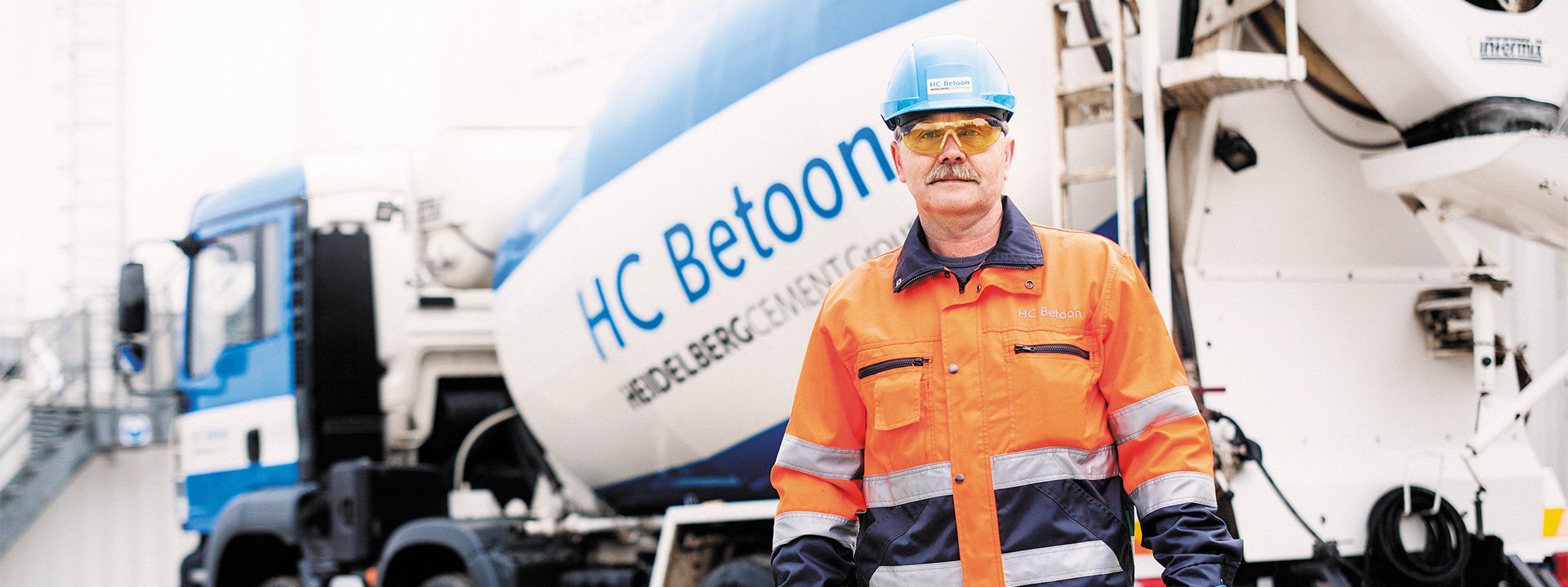 A man standing in front of a concrete mixer with the inscription HC Betoon
