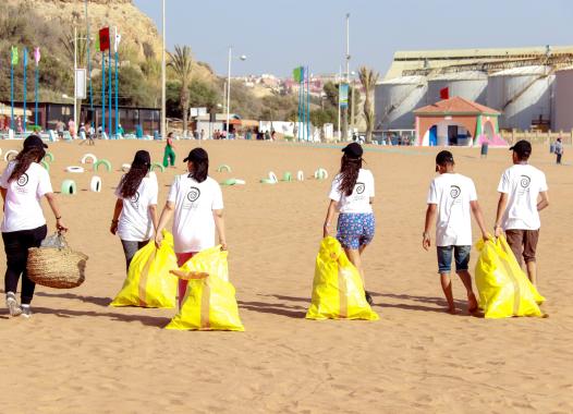Menschen mit Säcken am Strand